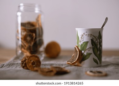 A selective focus of dried lemon tea in a white mug on a fabric surface