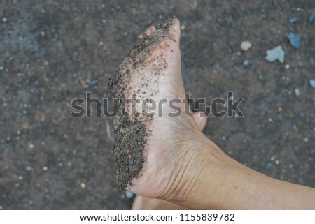 selective focus dust and soil stick on woman wet bare foot while walking on the ground