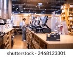 Selective focus to edge of POS machine with blurry cashier staff receive orders from customers at counter service in restaurant or cafe or department store. Post of sale Concept.