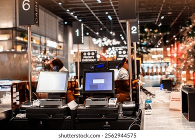 Selective focus to edge of POS machine with blurry cashier staff receive orders from customers at counter service in restaurant or cafe or department store. Post of sale Concept.