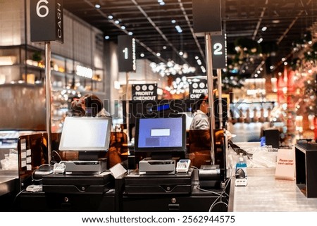 Selective focus to edge of POS machine with blurry cashier staff receive orders from customers at counter service in restaurant or cafe or department store. Post of sale Concept.