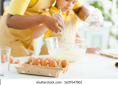 Selective Focus Of Eggs Near African American Kid And Mother Mixing Ingredients In Bowl