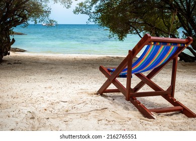 Selective focus. Empty deckchair on the beach. Beach lounger. Vacation concept. White sand beaches.