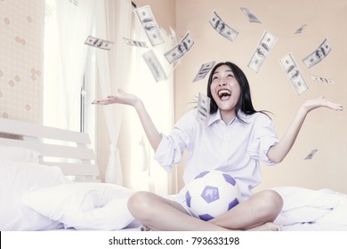 Selective focus of Excited cheerful smiling young asian beautiful girl throwing dollars in the air. Hipster girl and hundred dollar banknotes around her. Profits, motivtion. Vintage tone.