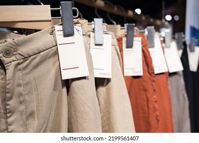 Selective Focus, Fashion , Clothes Concept ,Clothes Or Pants Many Colors Hang On A Shelf In A Designer Clothes Store. Lots Of Pastel-colored