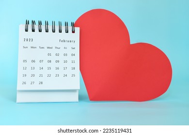 Selective focus of February 2023 desk calendar with big red heart shape on blue background with copy space. - Shutterstock ID 2235119431