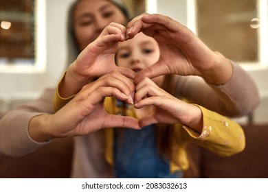 Selective Focus Female And Kid Hands Folded Together In Heart Shape. Cheerful Woman And Girl Showing Grateful Heart Sign. Fulillment Through Kindness.