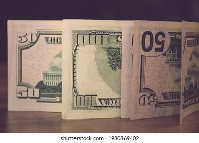 Selective Focus Of Fifty Dollar Bills And One Hundred Dollar Bills Upside Down. Details Of US Currency Paper Banknotes With Figures 50 And 100