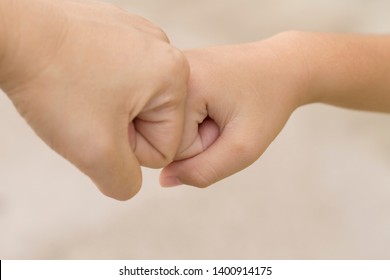 A Selective Focus Of A Fist Bump Between The Old And The Kid For Senses Of Encouragement And Joyfulness.