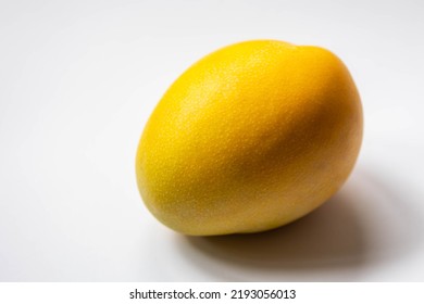 Selective Focus Of Fresh Ripe Yellow Fruit On White Background, A Mango Is An Edible Stone Fruit Produced By The Tropical Tree Mangifera Indica, Worldwide There Are Several Hundred Cultivars Of Mango.