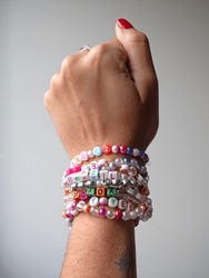 Selective Focus. Friendship Bracelets Made Of Handmade Plastic Beads. Set Of Bright Colorful Braided Bracelets With Words. Colored Ts Teen Jewelry.