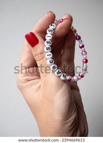 Selective focus. Friendship bracelets made of handmade plastic beads. Set of bright colorful braided bracelets with words. Colored ts teen jewelry.