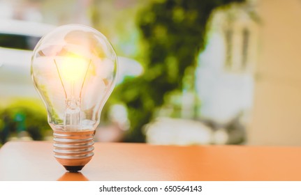 Selective focus glowing vintage light bulb, Realistic bulb image turn on tungsten light bulb isolated on outdoor background.