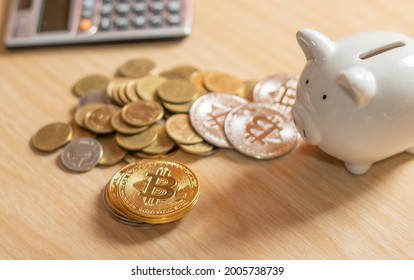 Selective Focus Gold Digital Crypto Currency Coin Set Background On Wooden Table With Piggy Bank And Calculator Ideas For Planning Savings For Future Retirement.