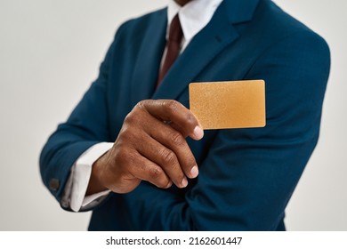 Selective Focus Of Golden Business Card In Hand Of Blurred African American Ceo Manager Or Entrepreneur. Man Wearing Suit. Concept Of Modern Successful Male Lifestyle. White Background. Studio Shoot