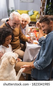 Selective Focus Of Golden Retriever Near Multicultural Family Celebrating Thanksgiving Day