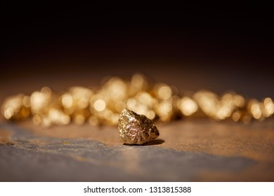 selective focus of golden stones on brown marble and blurred background