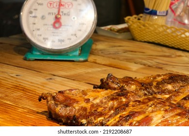 Selective Focus Grilled Pork Ribs. Ribs On A Messy Wooden Table Background With Weighing
