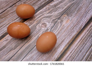 In selective focus a group of brown eggs on old wooden table background 