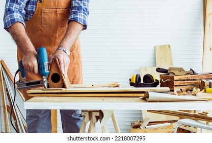 Selective focus hand drilling wood, making DIY wooden furniture, using equipment to drill woods with happiness while standing alone at indoor home. Retirement and Hobby Concept - Powered by Shutterstock