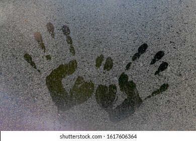 Two hand prints with raindrop on window with dust and dirty. 
