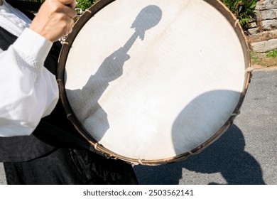 selective focus, hand of a person playing a bass drum. Traditional folk music from Galicia, Spain