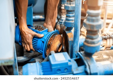 Selective focus to hand of plumber repair and remove motor of centrifugal water pump. Plumbers working to installation centrifugal water pump motor. - Powered by Shutterstock