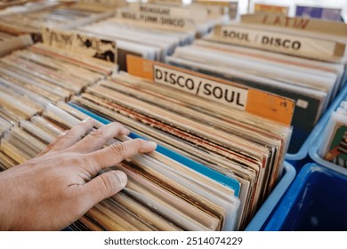 Selective focus at hand that pick and select second hand vinyl discs at the stall in open air market in Düsseldorf, Germany.  