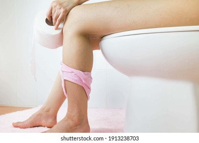 Selective focus Hand of woman in tissue bath sitting on toilet bowl.
