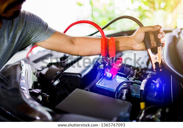 selective focus hands do charging car battery\
with electricity through cables from from other car, first connect\
anode then follow connect negative connector battery, power\
transfer concept.