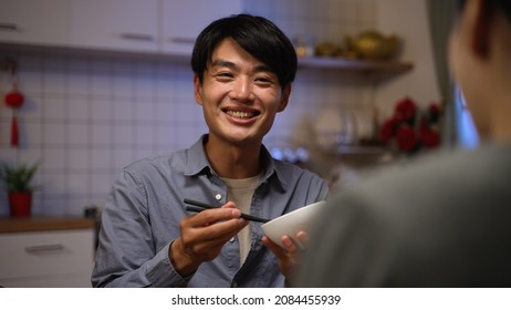 Selective Focus Of A Happy Asian Father Talking And Showing Surprise While Enjoying Tasty Reunion Dinner With Family On Chinese New Year's Eve