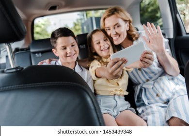 Selective Focus Of Happy Family Taking Selfie On Smartphone In Car 