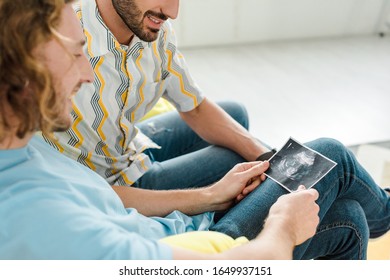 Selective Focus Of Happy Homosexual Men Looking At Ultrasound Scan