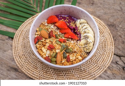 Selective Focus Healthy Food Acai Breakfast Superfoods Smoothie Bowl With Chia Seeds, Bee Pollen, Fresh Strawberry, Apple, Almond And Granola For Healthy Vegan 