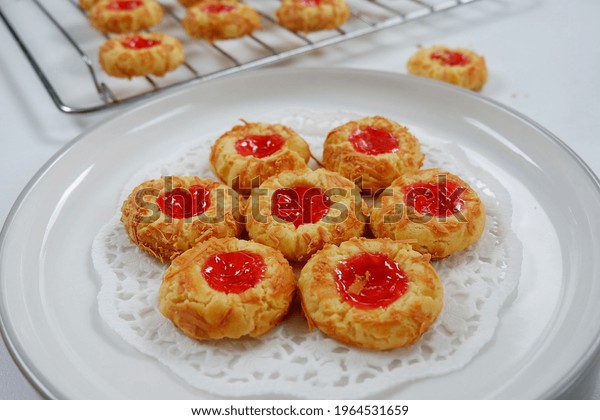 Selective\
focus of Homemade thumb print cookies filled with strawberry jam\
and grated cheese. Served for eid al fitr.\
