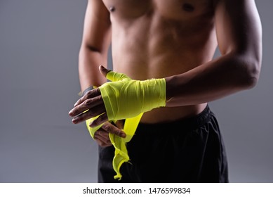 In selective focus of human hand  was wrapping yellow cloth ,prepare for punching exercie,blurry light around - Powered by Shutterstock