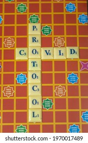 Selective focus image of alphabets on square coins used to depict the the word COVID PROTOCOL
