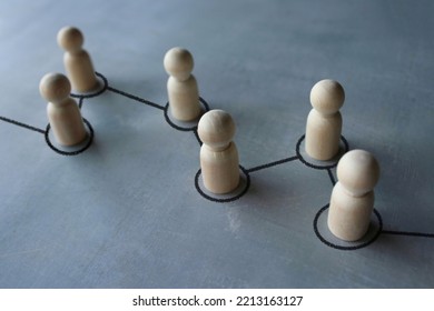 Selective focus image chain of wooden dolls connected by lines. Cooperation, interaction, communication and disseminating information concept - Shutterstock ID 2213163127