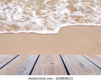Selective focus image of empty wooden table with sea wave background, image for display product display montage.