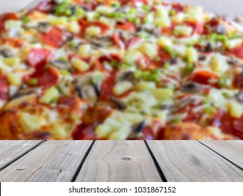 Selective Focus Image Of Empty Wooden Table With Blurred Delicious Pizza Shop Interior Background. Image For Used Display Or Montage Your Products.