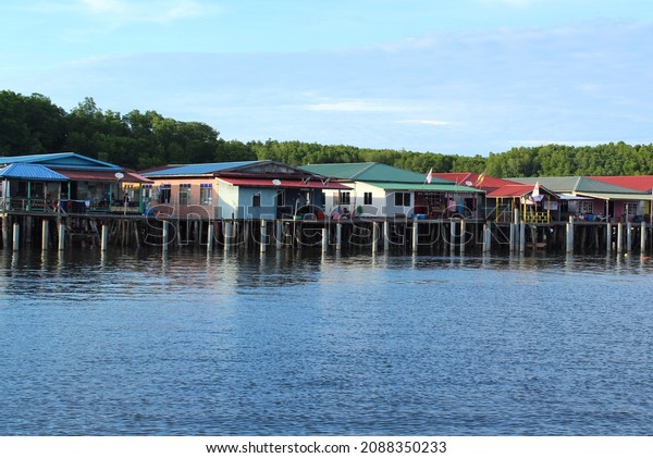Selective focus image of fishing village with\
wooden houses on stilts in the sea. Village of fishermen with\
houses on the water, with fishing\
boats