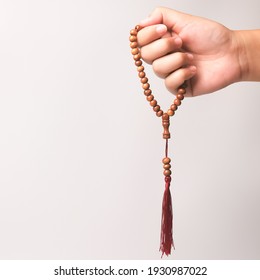 Selective focus image hand of muslim woman holding a prayer beads isolated on white background with copy space.