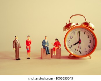 Selective focus image of miniature people  with alarm clockwork on white table background / with copy space,vintage style