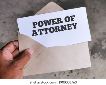 Selective focus image with noise effect hand holding envelope with white card written text POWER OF ATTORNEY.