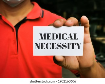 Selective focus image with noise effect hand holding white card with text MEDICAL NECESSITY.Medical concept.
