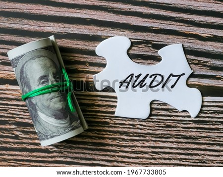 Selective focus image with noise effect phrase puzzle piece written audit with fake money. Business and finance concept.