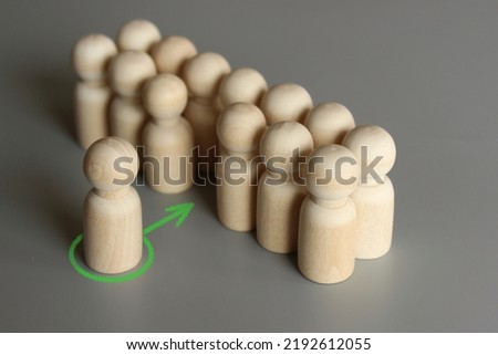 Selective focus image of one wooden doll join the group. New member, hiring, filling a vacancy concept.