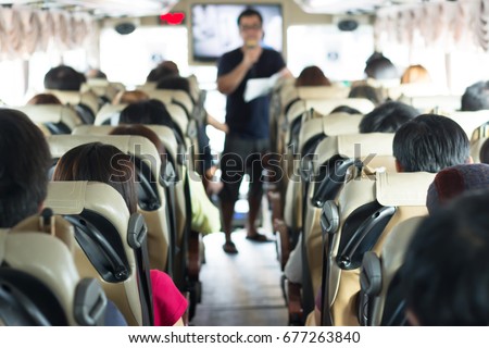 Selective focus image of Private bus with tourists and guided tour.
