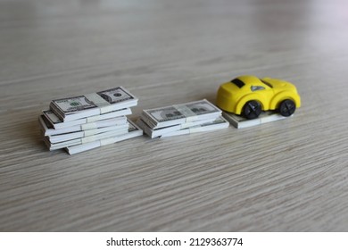 Selective Focus Image Of Toy Car And Stack Of Money. Car Depreciation, Value Concept.