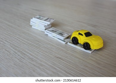 Selective Focus Image Of Toy Car And Stack Of Money. Car Depreciation, Value Concept.